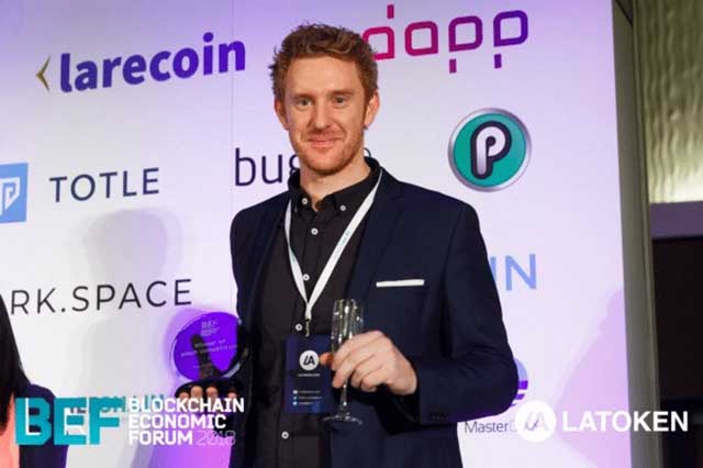 Luke Lombe from the PlayChip ICO team collecting the San Francisco Blockchain Economic Forum ICO Pitch ‘Draper Hero’s Choice Award’.