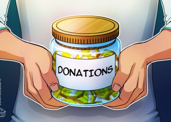 Hands holding a jar of coins with donations written on it