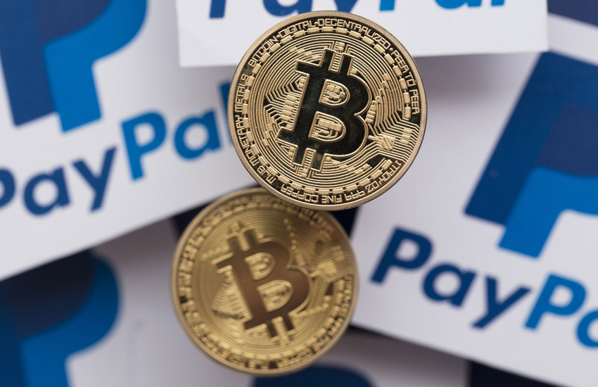 Two bitcoins on top of papers with PayPal symbol on them, representing payment methods using blockchain
