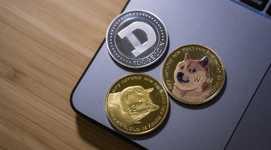 Picture of Baby Doge coin, Shiba Inu coin, and a Dogecoin on a laptop