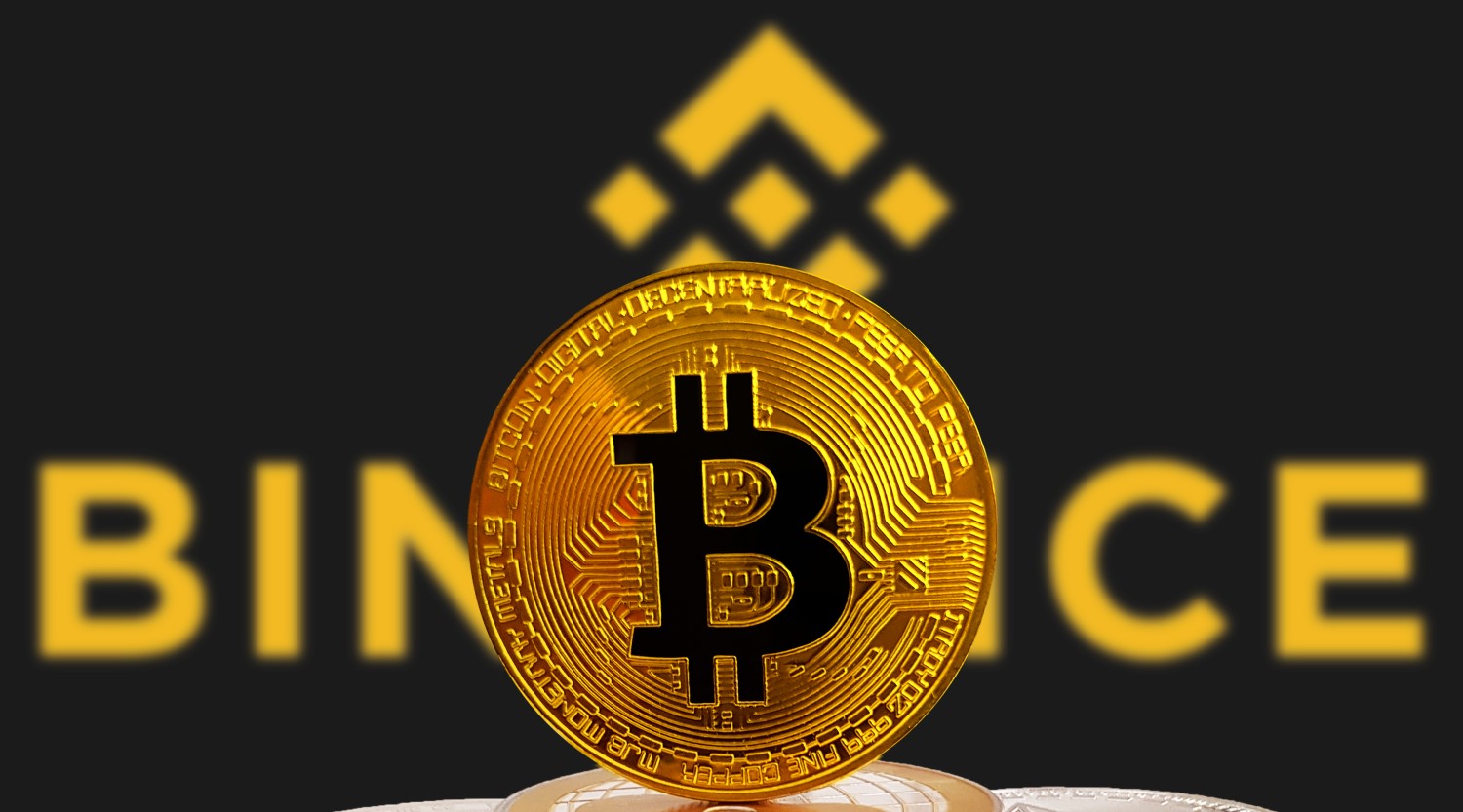 Picture of a bitcoin in front of the binance logo with binance written behind it