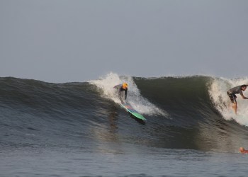 Bitcoin Beach, surfers over a wave