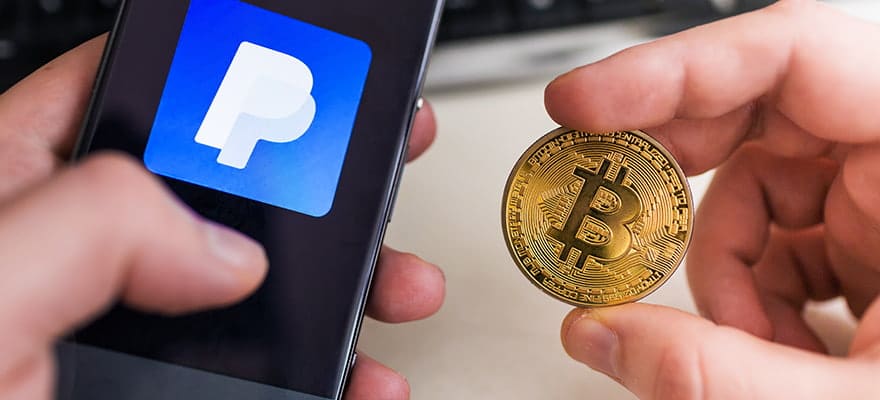 Picture of two hands with a mobile phone that says PayPal in one and a bitcoin crypto coin in the other