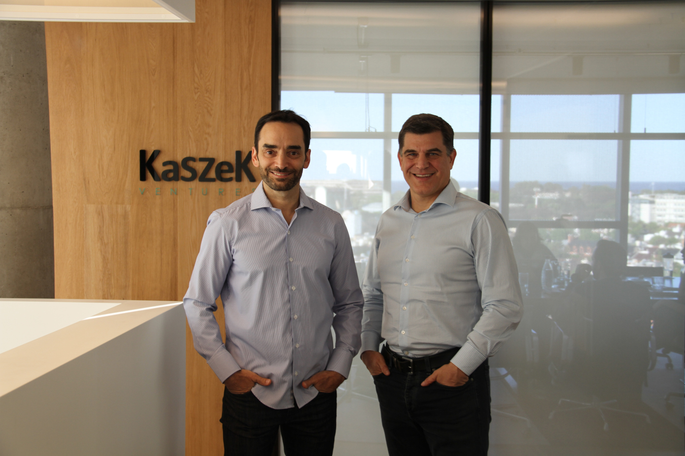 Kaszek founders standing in front of logo