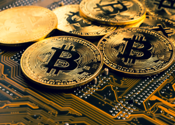 Picture bitcoins laying on top of a circuit board