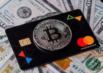 Picture of a bitcoin on top of a Mastercard, with dollar bills underneath them, as Australian exchange CoinJar release debit card