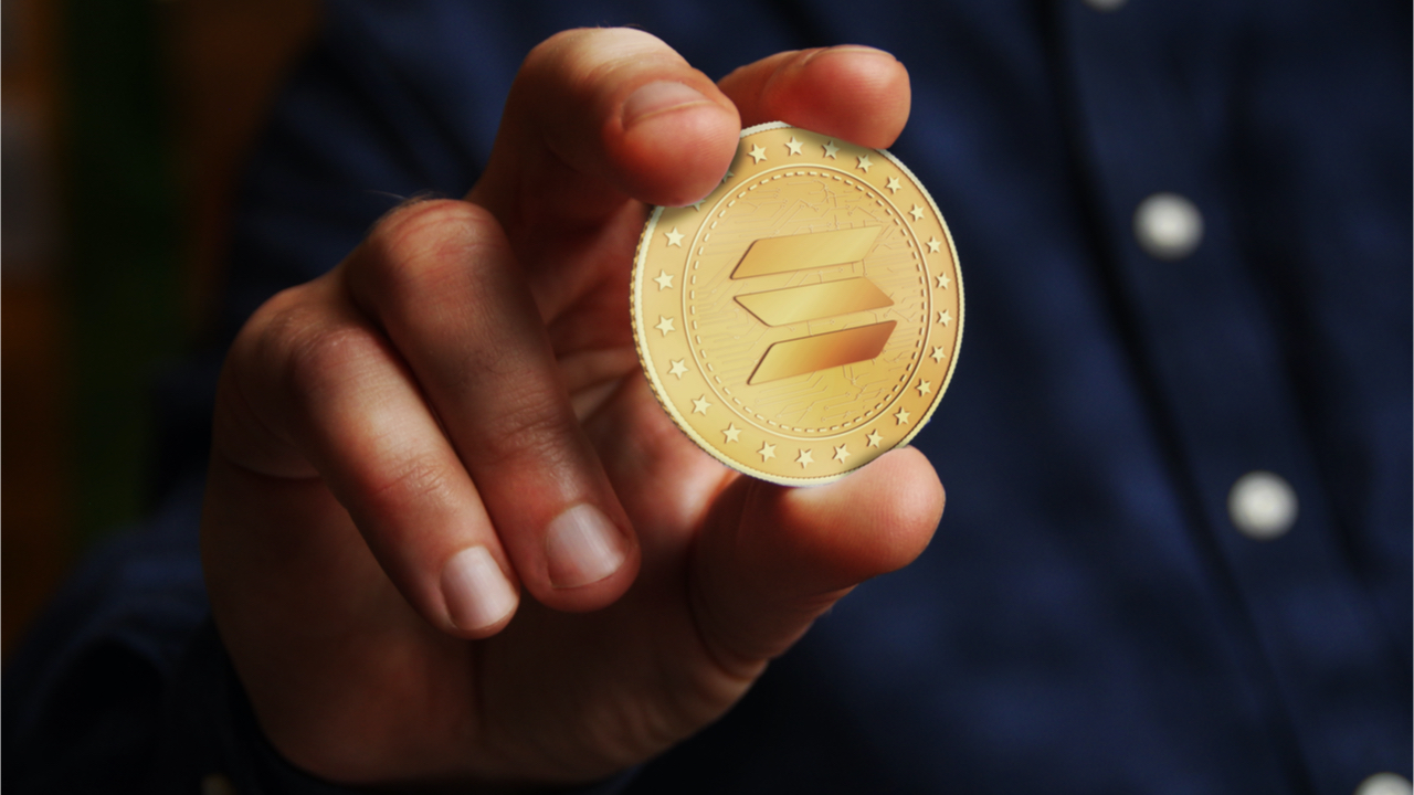 Picture of a hand holding a Solana coin