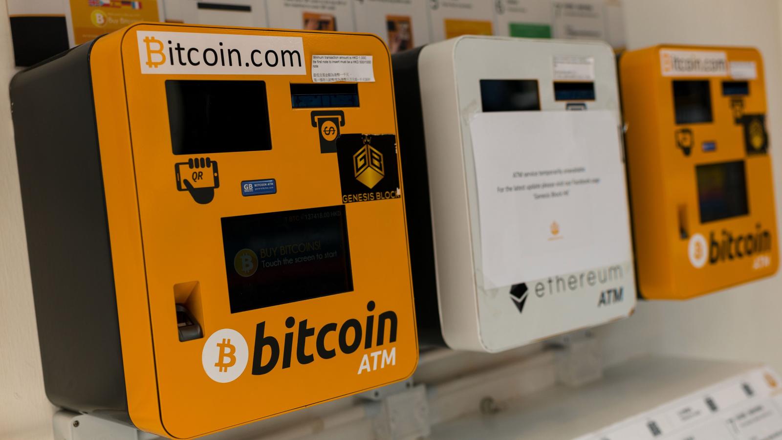 Bitcoin of three bitcoin ATMs mounted side by side on the wall