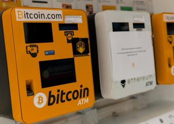 Bitcoin of three bitcoin ATMs mounted side by side on the wall