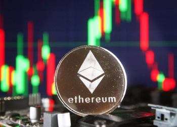 Picture of a silver ETH coin in front of a green and red candlestick chart