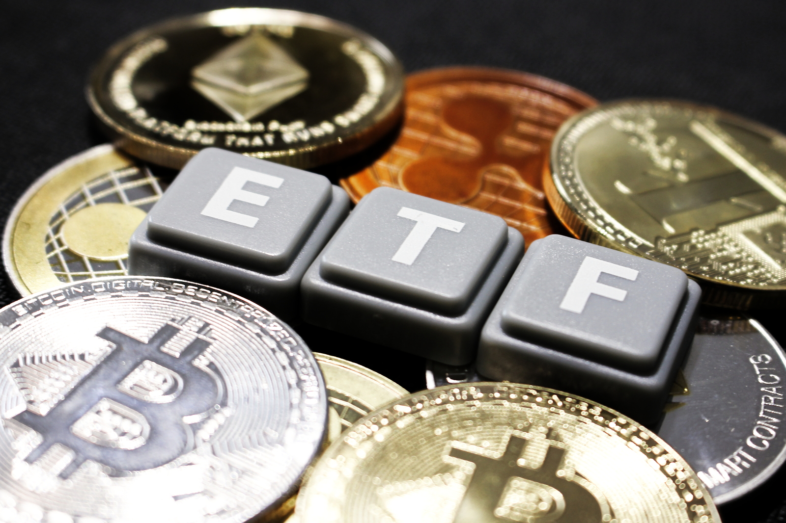 Picture of ETF written with scrabble tiles with crypto coins around it