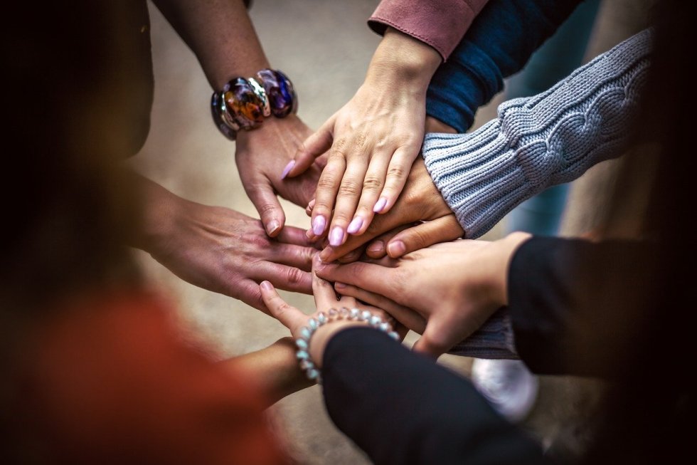Bitcoin for Communities, hands doing the "all for one "