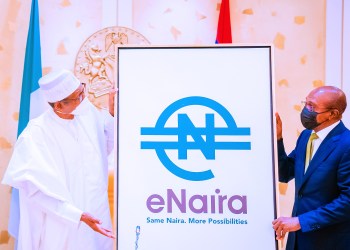 Nigerian president holding a picture with eNaira on it