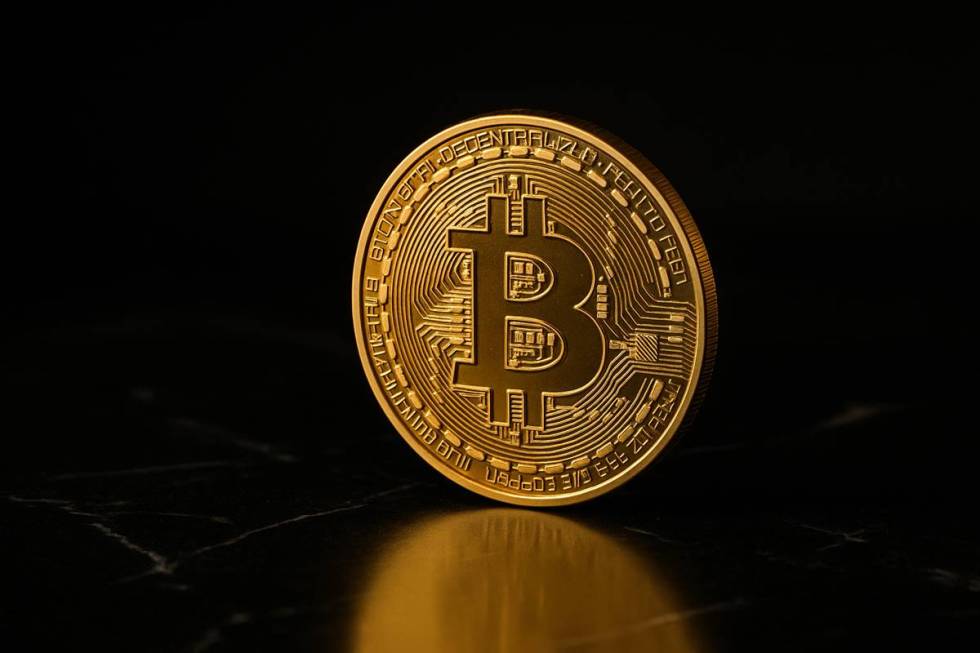 เหรียญ Bitcoin สีทองเดี่ยวบนพื้นหินอ่อนสีดำหรูหรา