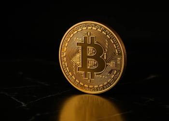 เหรียญ Bitcoin สีทองเดี่ยวบนพื้นหินอ่อนสีดำหรูหรา