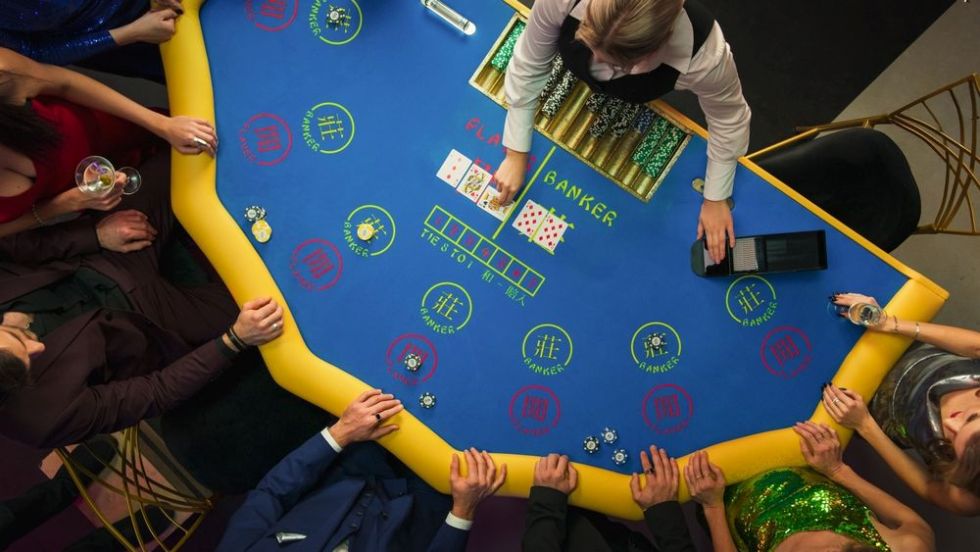 테이블에서 바카라를 즐기는 플레이어들과 딜러