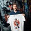 Martin Masser, ChangeNOW’s Director of Strategic Partnerships, holds a branded T-shirt in a graffiti-covered London passage.